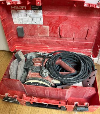 une boîte à outils rouge avec des outils sur le sol