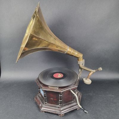 un vieux gramophone posé sur un support avec un socle en bois