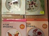 quatre kits de broderie au point de croix dans une boîte ornée d'un papillon