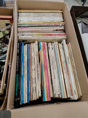 une boîte pleine de livres posée sur le sol