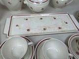 a white table topped with a tray and cups and saucers
