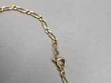 a close up of a gold chain bracelet on a table