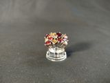a red and gold ring sitting on top of a black surface
