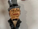 two figurines of a man with a top hat and a top hat on top of a bottle opener