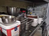 many pots and pans on the shelves in the kitchen