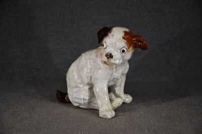 une petite figurine représentant un chien assis sur une table