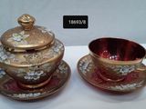 two cups and saucers sitting on a table next to each other