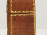an old leather book with gold trimmings on the cover