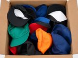 une boîte en carton remplie de chapeaux de toutes les couleurs
