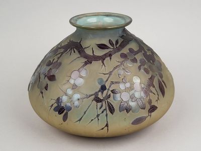 a glass vase with flowers on it sitting on a table