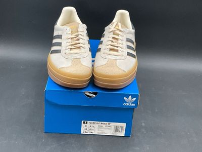 adidas superstar shoes in a box on a grey surface