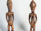 une paire de figurines en bois représentant un homme et une femme debout l'un à côté de l'autre