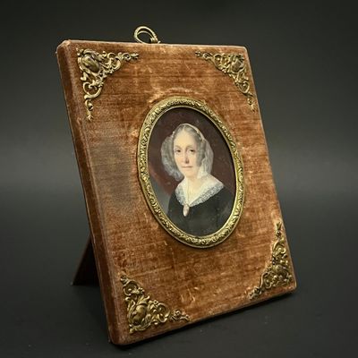 portrait d'une femme en robe noire avec un cadre doré