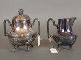 two silver teapots sitting next to each other on a table