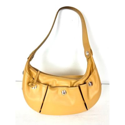 sac à main en cuir jaune avec des anses en métal sur un fond blanc