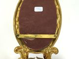 a gold frame with a mirror and two candles on it