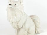 a white dog figurine sitting on a white surface