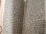 a person holding an open book in their hand