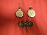 two pieces of silver jewelry on a red cloth with a red background