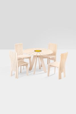 a wooden table with chairs and a bowl of fruit on it