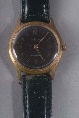 a gold wrist watch with a black face on a black strap