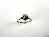 an image of a diamond ring sitting on top of a white surface