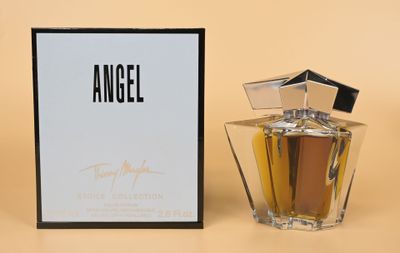 an angel perfume bottle next to a box on a table