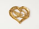 an image of a gold heart shaped brooch on a white background