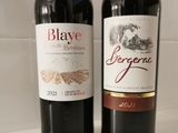 two bottles of wine sitting next to each other on a counter