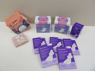 plusieurs paquets de coussinets d'allaitement posés sur une table blanche
