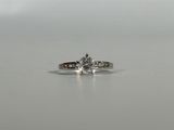 a close up of a diamond ring on a white surface