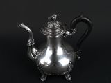 a silver teapot with a crown on the top of it