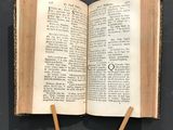 an open book with two wooden sticks sticking out of it