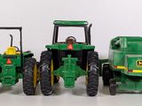three toy tractors sitting next to each other on a table