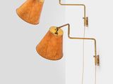 a pair of brass wall lamps on a white wall next to a white wall