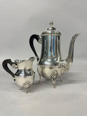 a silver plated tea set with two cups and a saucer