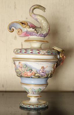 a vase with a swan on top of it on a table