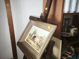 a picture of a painting on a easel in the corner of a room