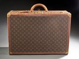 an old louis vuitton suitcase sitting on top of a table