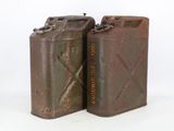two old metal cans are sitting next to each other on a white surface