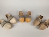quatre paires de sabots sont alignées sur une surface blanche