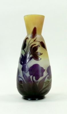 un vase orné d'une fleur violette sur un fond blanc
