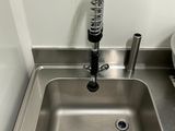 un évier en acier inoxydable dans le coin d'une salle de bains