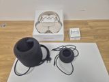 a black speaker sitting on top of a table next to a white box