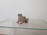 une étagère en verre sur laquelle est posée une figurine de grenouille
