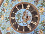 a clock that is painted with animals and flowers on it