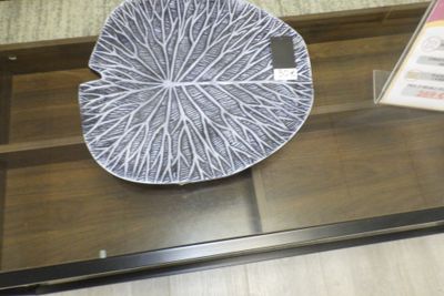 une assiette décorative exposée sur une table en verre