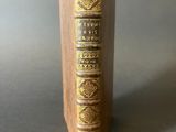 an old book sitting on top of a wooden book stand