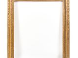 un cadre doré sur un mur blanc, avec un fond blanc