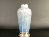 a blue and white vase sitting on a black table